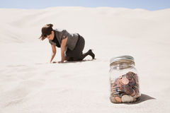 woman-searching-jar-coins-desert-62807590.jpg